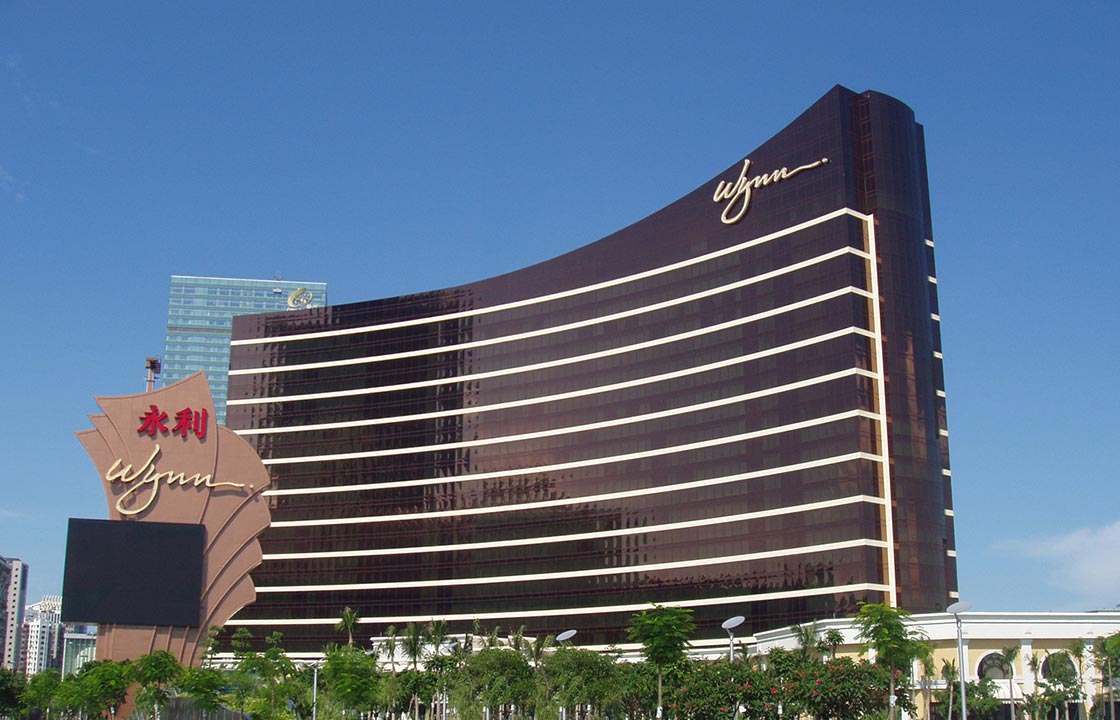 the wynn macau hotel in china standing above green trees at its base