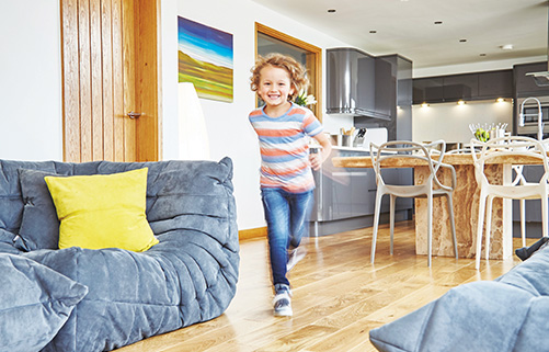 Toddler running through a living room fitted with a sound reducing underlay